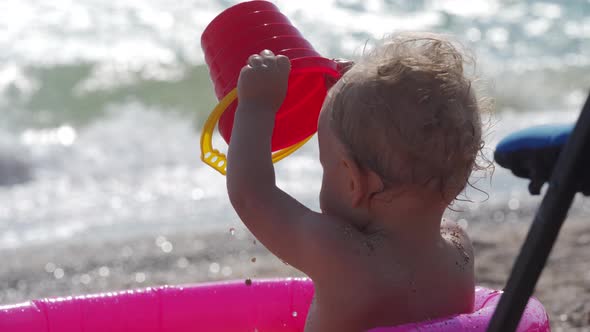 Happy Baby Boy Having Fun in Inflatable Pool for Kids on the Sea Beach Smiling Child Toddler Playing