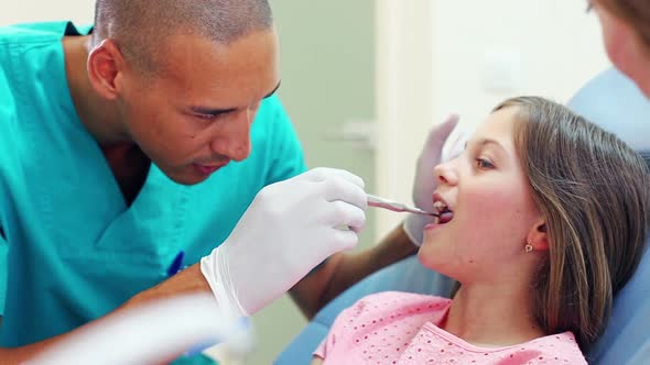 male dental surgeon examining a little girl