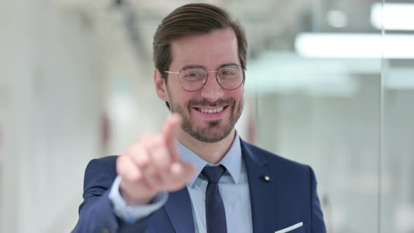Portrait of Assertive Young Businessman with Pointing at the Camera