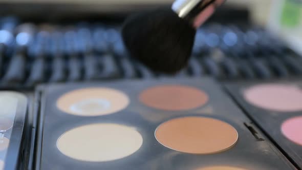 Close up View of Makeup Brush Moving Over Skin and Eyeshadow Color Palette