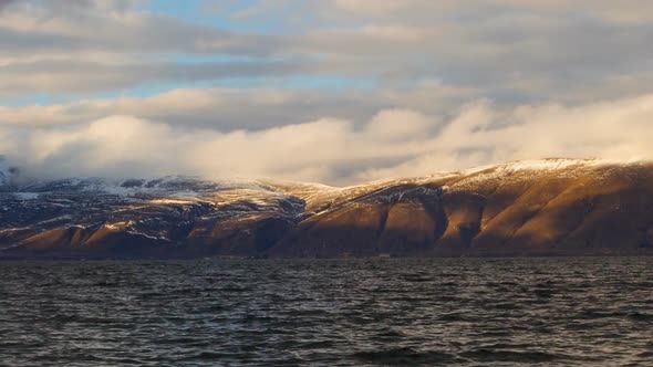 Daytime Timelapse of Moving White Clouds Over Lake Sevan on Background Hills