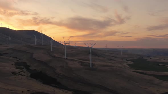 Aerial Landscape View of Wind Turbines on a Windy Hill during a colorful sunrise. Taken in Washingto