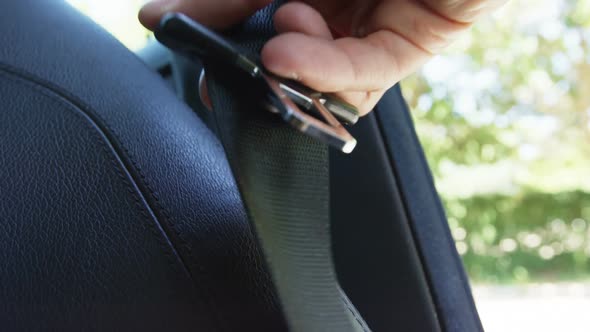 Hand holding seat belt of car