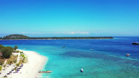 Aerial drone shot panorama of tranquil resort beach time by blue water with white sandy background o