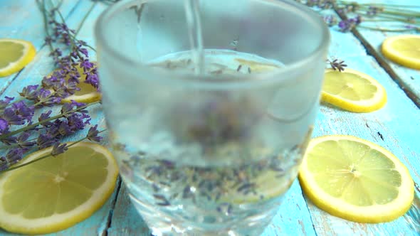 Preparation of lemonade from fresh lavender flowers, lemon on a wooden vintage background. 