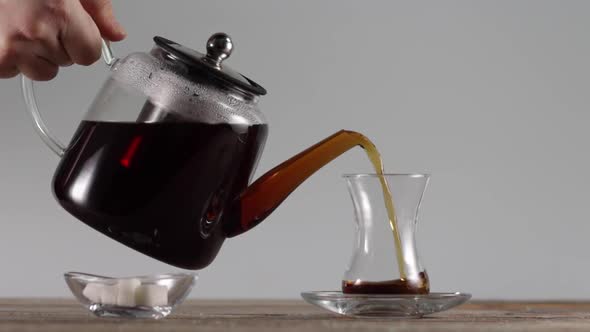 Pouring Tea From a Kettle in a Cup