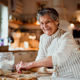 Elderly woman making cakes in a kitchen at home. Copy space.