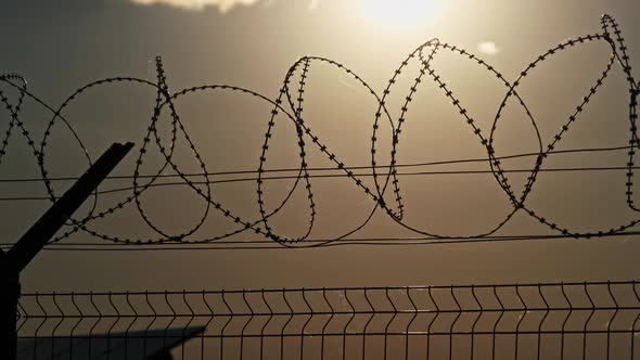 Razor Wire on the Fence Against the Sunset