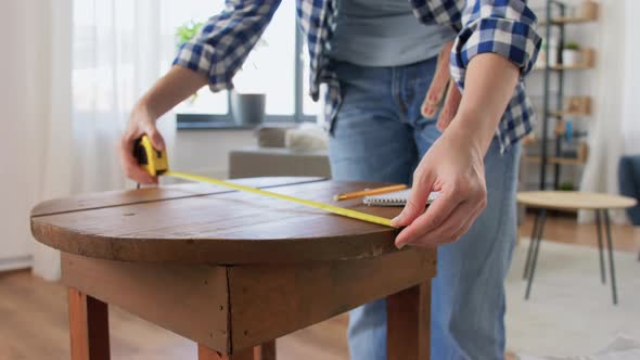 Woman with Ruler Measuring Table for Renovation