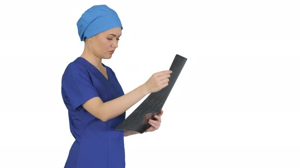 Serious Female Doctor Looking at MRI Scan of Brain on White Background.