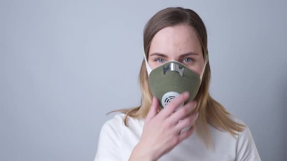 Close-up Portrait of a Woman Removes a Respiratory Face Mask During the Quarantine of the COVID-19