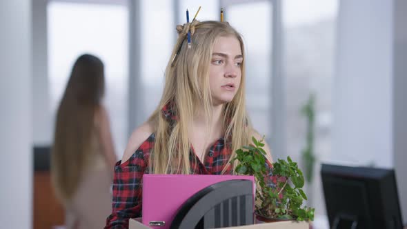 Arrogant Millennial Woman Standing in Office Chewing Gum and Holding Cardboard Box with Belongings