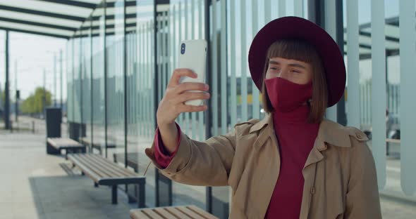 Young Woman in Cotton Mask Taking Selfies Near Modern Glass Building, Attractive Millennial Girl