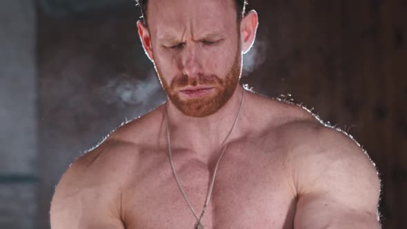 An Athletic Man Covering His Hands in Chalk and Clapping  Looking in the Camera