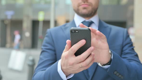Hands Close up of Businessman using Smartphone while Standing in Street
