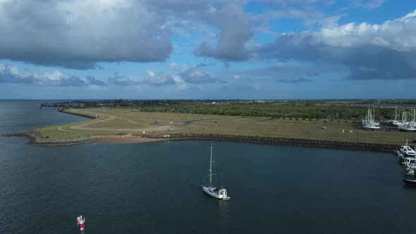 A high drone perspectiveing over a small yacht anchored in a protected harbor located in the town of
