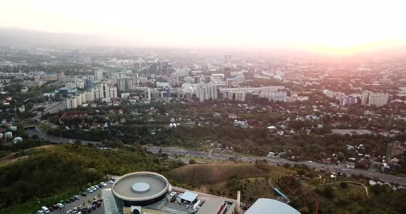 Ferris wheel at sunset overlooking the city and mountains. Almaty, Kazakhstan.