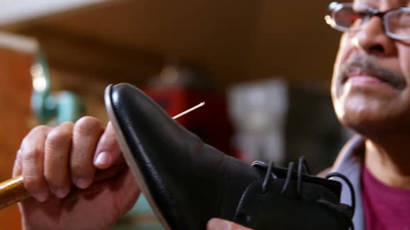 Shoemaker repairing a shoe