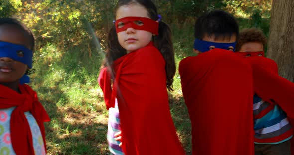 Friends pretending to be a superhero in park