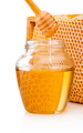 Honey dripping from dipper into glass jar on background honeycom - PhotoDune Item for Sale