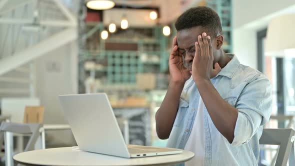 Hardworking Young African Man with Laptop Having Headache