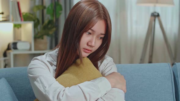 Unhappy Lonely Depressed Young Asian Woman At Home, She Is Sitting On The Couch, Depression Concept