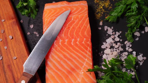 Delicious Fresh Salmon with Salt and Spices on a Black Stone Table