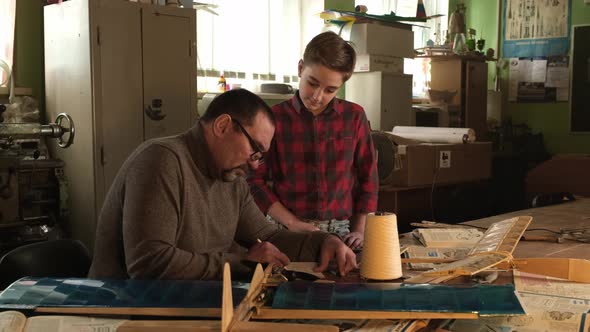 Teacher and Student Make a Drawing of an Airplane Model