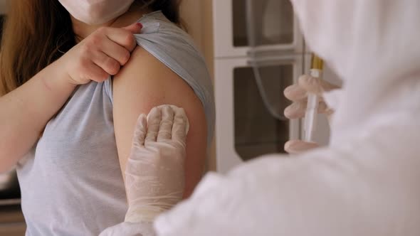 A Doctor in a Protective Suit Injects a Coronavirus Vaccine at Home