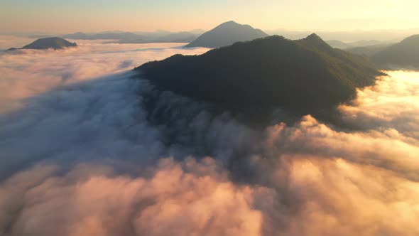 4K Scenic flight over beautiful mountain scape with bright sky and clouds on summer sunrise