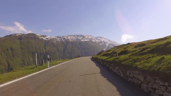 Driving on panoramic road through Swiss Alps. First Person POV