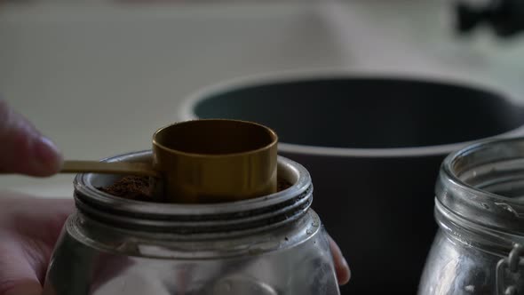 Woman make a coffee in moka pot in kitchen