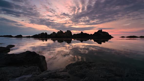 Colorful sunrise sky at rocky coastline