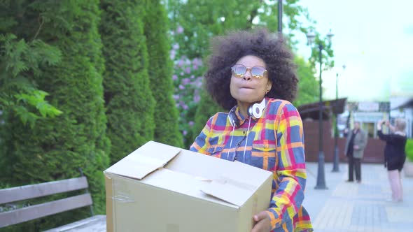 Portrait African American Woman with an Afro Hairstyle He Walks Down the Street with a Box in His