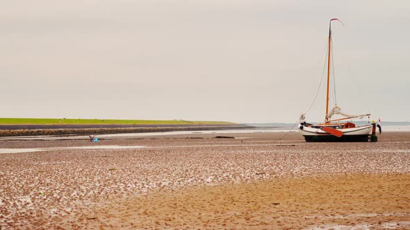 sailing boat dry on tidal mud flat Wadden Sea Netherlands timelapse ZOOM IN