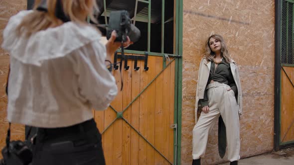 Photographer Taking Pictures of Woman in Stable