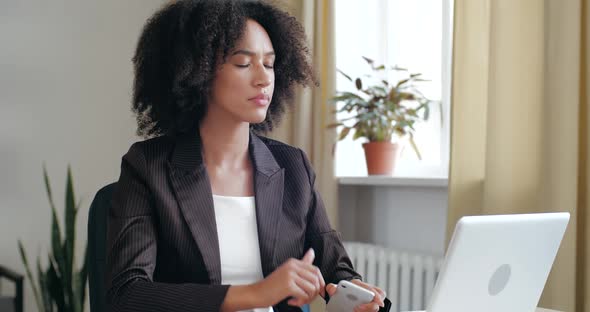 Attractive Girl Sits at Table, Surf the Internet, Uses Phone To Communicate and Solve Problems