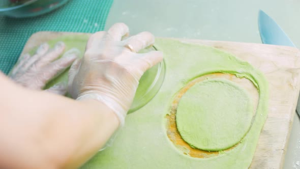 The Chef Forms Round Dough From the Green Dough with a Transparent Bowl