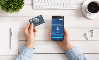 Woman using credit card and bitcoin earning mobile app