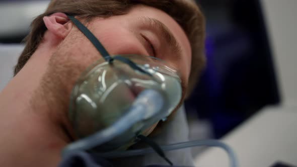 Unconscious Man Breathing in Oxygen Mask