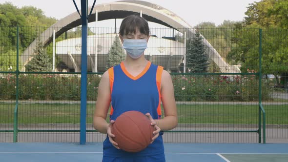 Portrait of a Young Girl Basketball Player in a Medical Mask Looking at the Camera. A Teenager