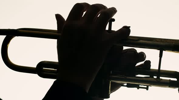 Closeup of Male Hands Playing Trumpet on White Background