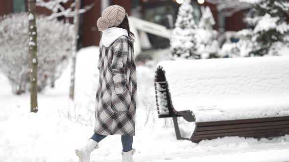 Casual Dressed Young Townswoman Is Walking at Winter Day Snowy Alley in Park or Yard of House