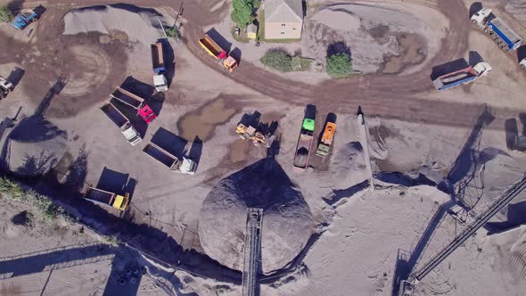 Excavators and Tractors Load Crushed Stone and Rock Into Dump Trucks