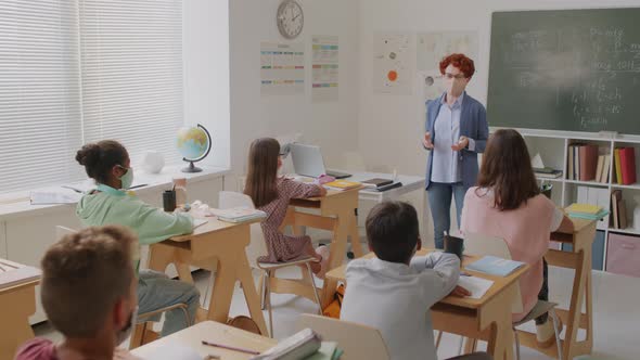 Teacher and Children in Face Masks in Classroom