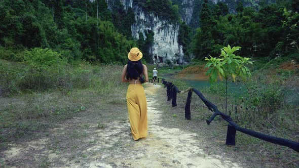 Cute Smiling Asian Girl Walking on a Trail in Cheow Lan Lake Thailand