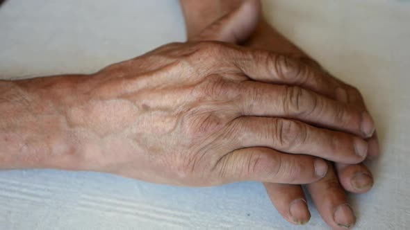 Close-up of the wrinkled hands of an elderly Caucasian man.