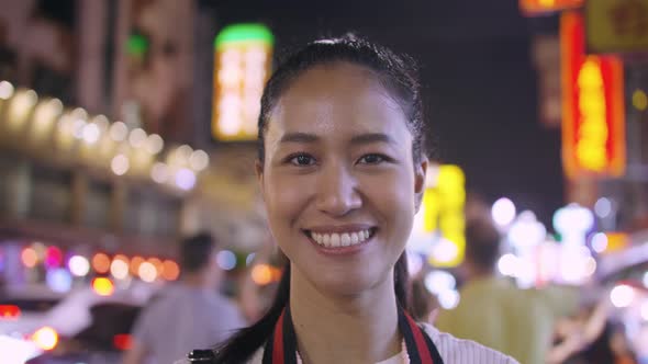 beautiful woman taking off a medical mask and smiling on the background of a city at night.