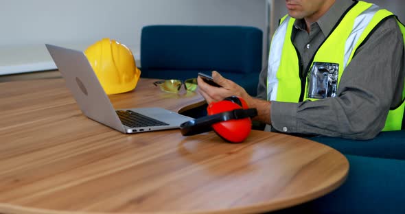 Male worker using mobile phone at desk 4k