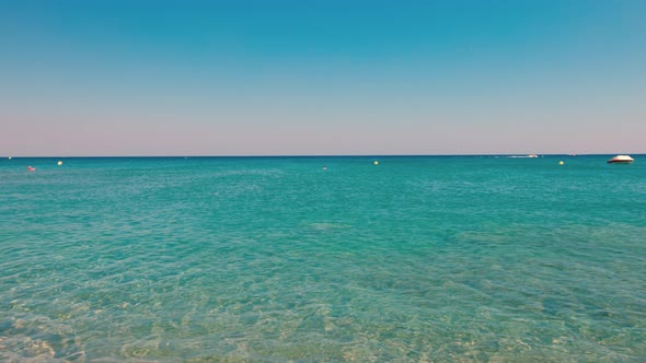 Beautiful view of turquoise water of Mediterranean Sea. Сoastline merges with surface and blue sky.